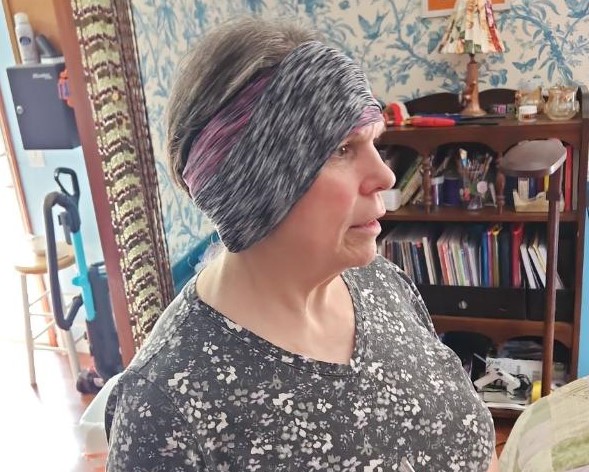 Dara wearing charcoal and flaxseed poultices over both ears, held with wide sweatbands