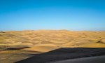 Desert sand under a wide blue sky