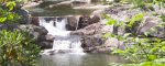 A waterfall spilling over rocks into a deep mountain pool