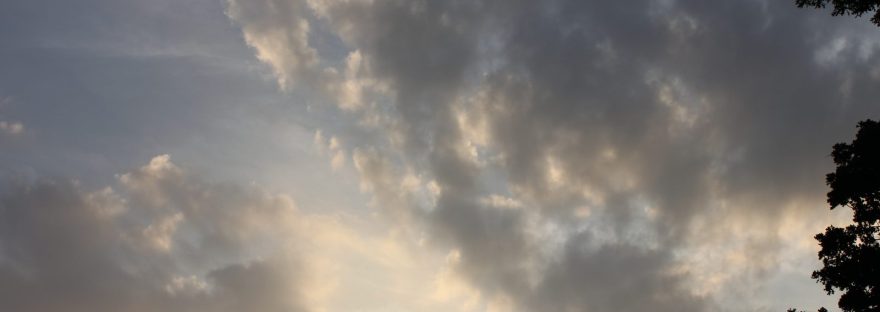 Golden light breaking behind gray clouds