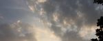 Golden light breaking behind gray clouds
